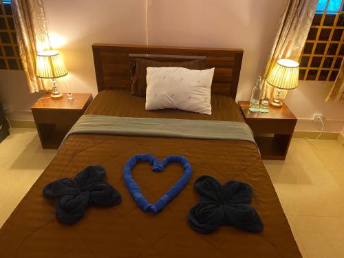 a bed with two towels in the shape of a heart at Bloom Garden Bed & Breakfast in Siem Reap