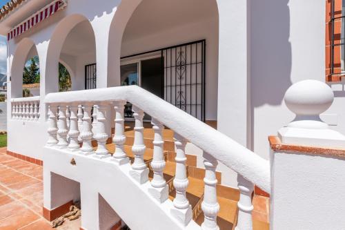 a white staircase in a house with a door at VILLA ALEGRIA Big terrace, private pool & parking in Mijas