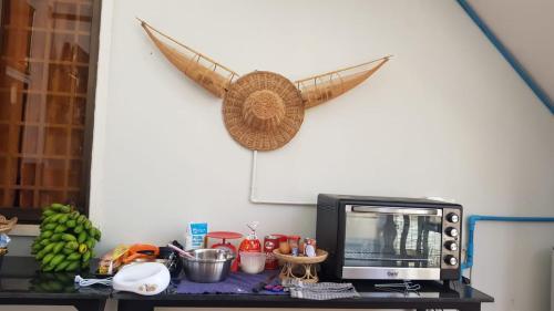 a microwave on a table with a boat on the wall at Bloom Garden Bed & Breakfast in Siem Reap