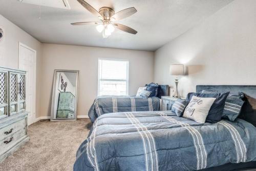 1 dormitorio con 2 camas y ventilador de techo en Mpressive Retreat!, en Grand Prairie