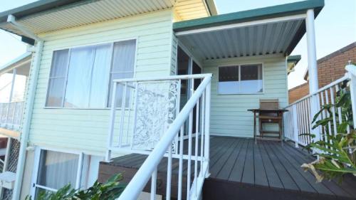 a front porch of a house with a white railing at Unit 2 5 Pilot St Yamba in Yamba