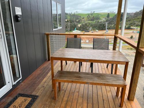 a wooden table and bench on a deck at Derby Digs Cabin in Derby