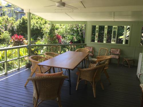 a wooden table and chairs on a porch at Pottsville Beach House in Pottsville