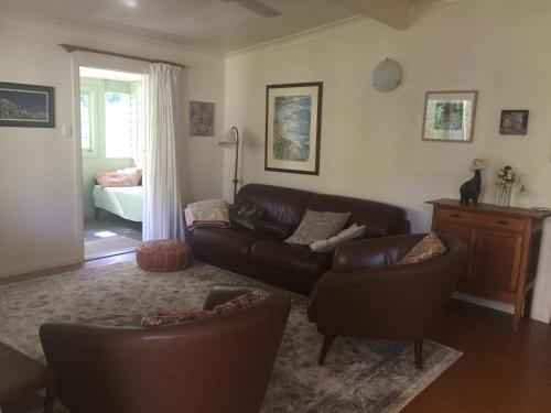a living room with a couch and chairs and a bed at Pottsville Beach House in Pottsville