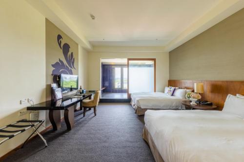a hotel room with two beds and a desk at South Garden Hotels And Resorts in Zhongli