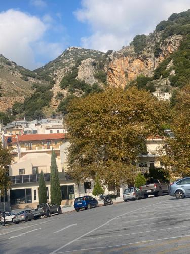 a parking lot with cars parked in front of a mountain at Costas Inn in Spílion