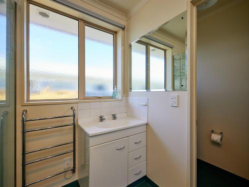 カイコウラにあるTorquay Central - Kaikoura Holiday Homeのバスルーム(シンク、窓2つ付)