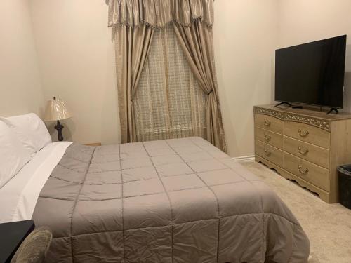 a bedroom with a bed and a dresser with a television at LuxHome Suites in Mansion in Riverside
