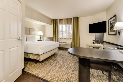 a hotel room with a bed and a desk at Candlewood Suites Portland Airport, an IHG Hotel in Portland