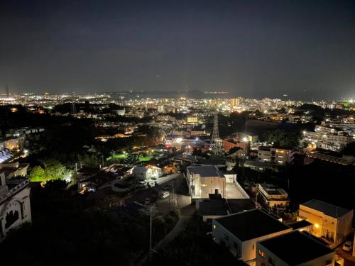 a view of a city at night with lights at HOTEL PACIFIC VIEW Rental car included & pet-friendly in Okinawa City