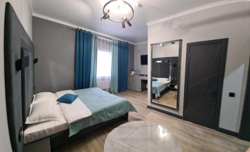 a bedroom with a bed and a large mirror at Гостинично-банный комплекс PARADISE in Shchūchīnsk