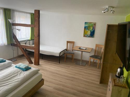 Zimmer mit einem Etagenbett, einem Tisch und Stühlen in der Unterkunft Bett & Bike Hansehof in Salzwedel