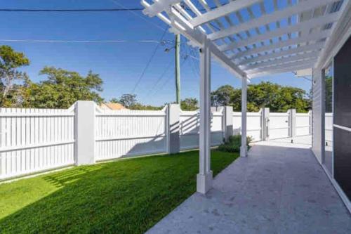 a white fence with a white pergola at Cute annexe - close to Manly Marina in Brisbane