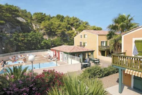 un complejo con una piscina con gente sentada a su alrededor en APPART 34 m2 - 300m de la plage - 4 pers - piscine - parking privé, en Narbonne-Plage