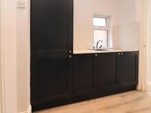 a bathroom with a sink and a black door at 37 Nutter Road in Cleveleys