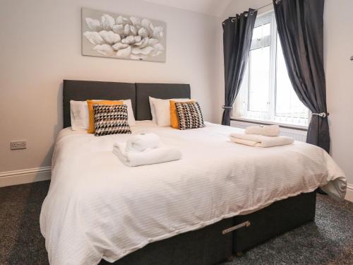 um quarto com uma cama grande e toalhas em 37 Nutter Road em Cleveleys