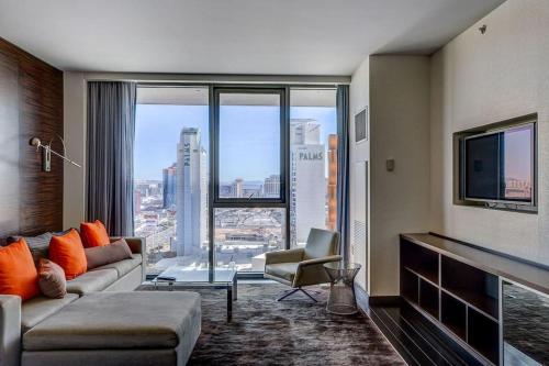 a living room with a couch and a large window at Strip View Luxury Studio No Resort Fee Palms Place in Las Vegas