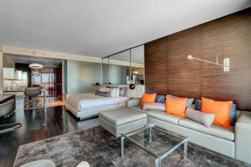 a living room with a bed and a couch and a bedroom at Strip View Luxury Studio No Resort Fee Palms Place in Las Vegas