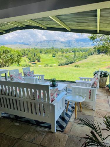a patio with chairs and a table and a view at Porterfield Guest House, Champagne Valley in Champagne Valley