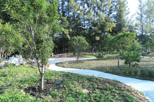 a winding path in a park with a tree at Moon River Village in Ban Bu Khanun