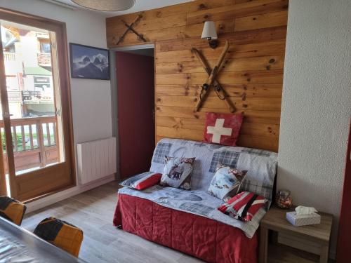Un dormitorio con una pared de madera con una cruz. en Agréable appartement de 6 pers au pieds des pistes ,wifi gratuit à Saint-Sorlin-d'Arves labelise 3 étoiles au gîte de France en Saint-Sorlin-dʼArves