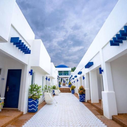 une cour d'un bâtiment blanc avec des pots bleus dans l'établissement Ruhe Suites Coron, à Coron