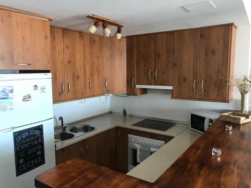 eine Küche mit Holzschränken und einer hölzernen Arbeitsplatte in der Unterkunft Apartamento Mateo Carboneras in Carboneras