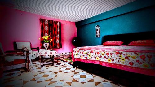 a bedroom with a bed with pink and blue walls at The Chakras Valley Homestay in Almora