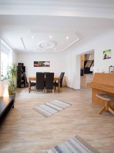 a living room with a table and a piano at Ferienhaus Müller in Merzig
