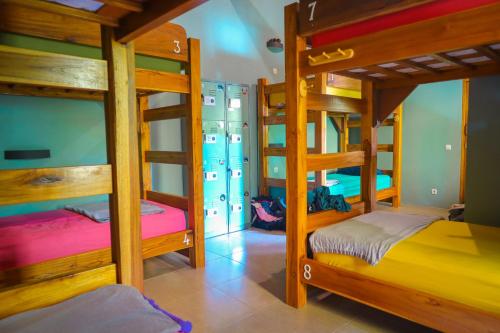 a room with three bunk beds in a house at Pipes Hostel in Kuta Lombok