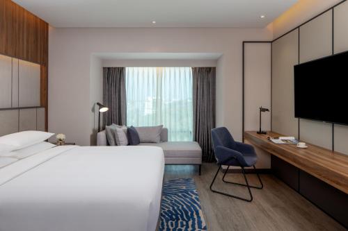 a hotel room with a bed and a tv at Hyatt Regency Trivandrum in Trivandrum