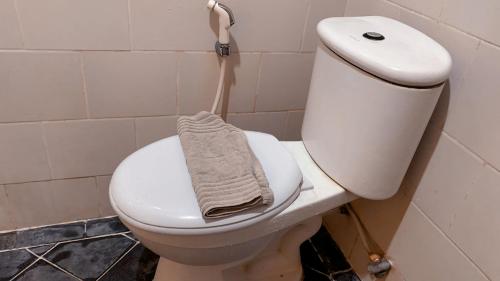 a white toilet in a bathroom with a towel on it at Hotel Syariah Larismanis in Semarang