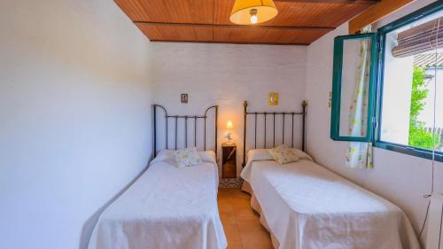 two beds in a small room with a window at El Garrotal - El Pan El Bosque by Ruralidays in El Bosque