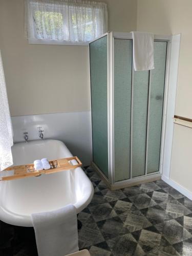 a bathroom with a white tub and a shower at Harbour Master's Cottage in Stanley