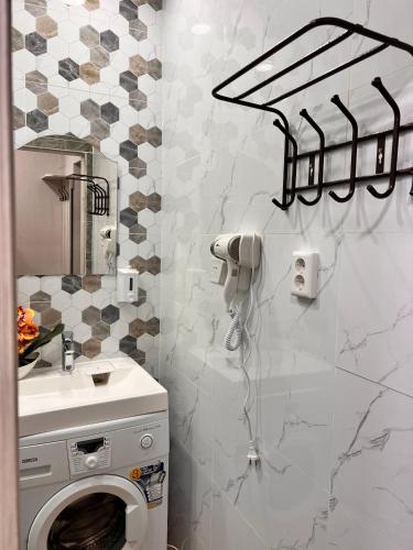 a bathroom with a washing machine and a sink at Sport Hotel Terra in Ustʼ-Kamenogorsk