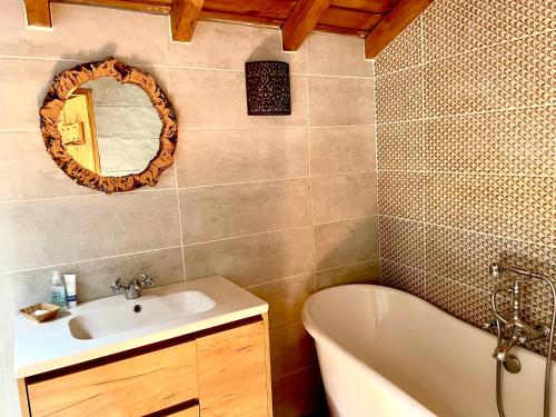 uma casa de banho com uma banheira, um lavatório e um espelho. em Casa Pollard em Marvão