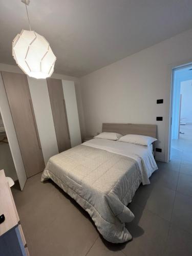 a white bedroom with a bed and a light at Donati Business Rooms in Subbiano