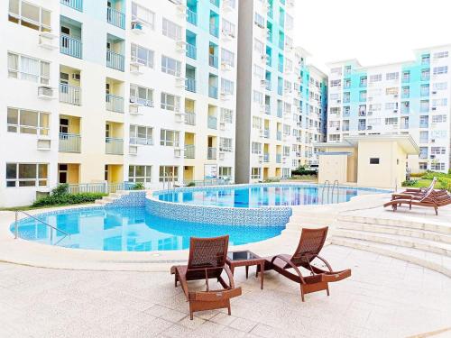 a swimming pool with two chairs and a building at 4th- Sea View of Seawind Condominium in Davao City