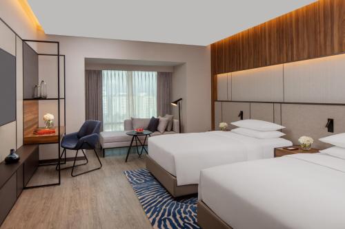 a hotel room with two beds and a desk at Hyatt Regency Trivandrum in Trivandrum