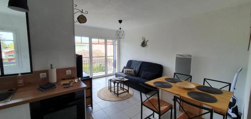 cocina y sala de estar con mesa y sillas en Colibri Appart' T2 au coeur du Bassin d'Arcachon, en Gujan-Mestras