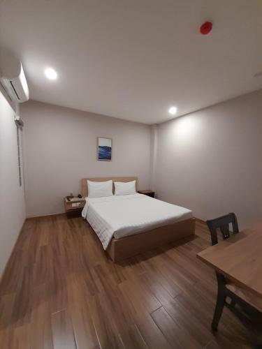 a bedroom with a bed and a wooden floor at Happy Home in Nha Trang