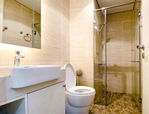 een badkamer met een toilet, een wastafel en een douche bij Vinhomes Dcapital luxury appartment in Hanoi