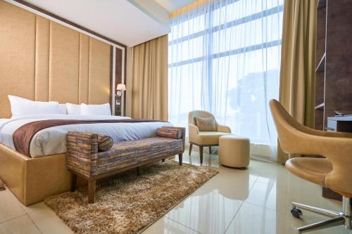 um quarto de hotel com uma cama e uma cadeira em Monty Suites Lekki em Lagos