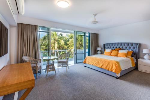 a bedroom with a bed and a balcony with a table at Yacht Harbour Tower 2, Hamilton Island - Million Dollar Views, Buggy & Valet Service in Hamilton Island