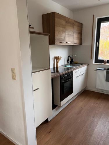 a small kitchen with a refrigerator and a sink at Monteurunterkunft Heger - Beste Verkehrsanbindung in Aalen