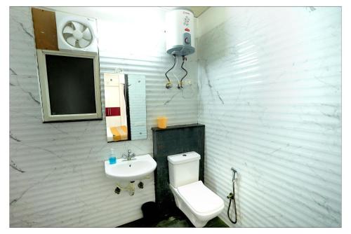 uma casa de banho com um WC e um lavatório em Gupta Residency em Noida