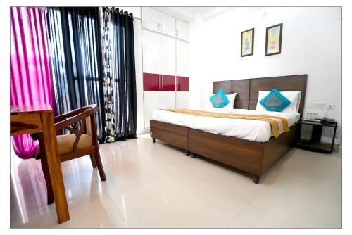 um quarto com uma cama, uma cadeira e uma secretária em Gupta Residency em Noida