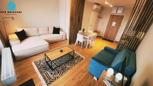 a living room with a couch and a table at Pod Brzozami Apartamenty Gąski in Gąski