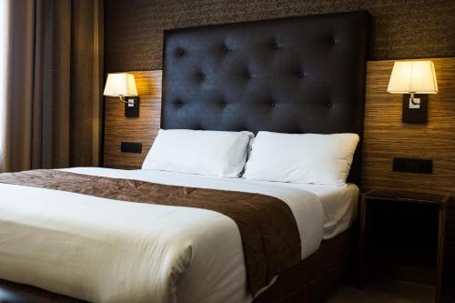 a bedroom with a large bed with a large headboard at Hyllit Hotel in Antwerp