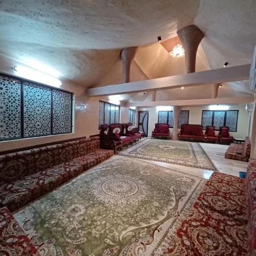 a living room with a couch and a large rug at Cloudy Cloud Farm Resort in Izkī